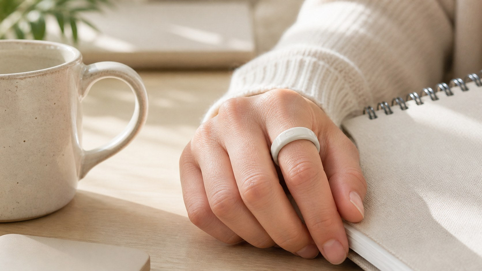 Bandsmith Cloud ceramic-color painted TPU Oura Ring cover worn during a quiet desk routine